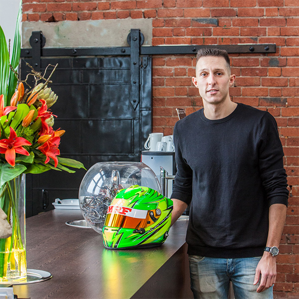 Dylan Young posing at Vista Eyes clinic with his F1 helmet. 